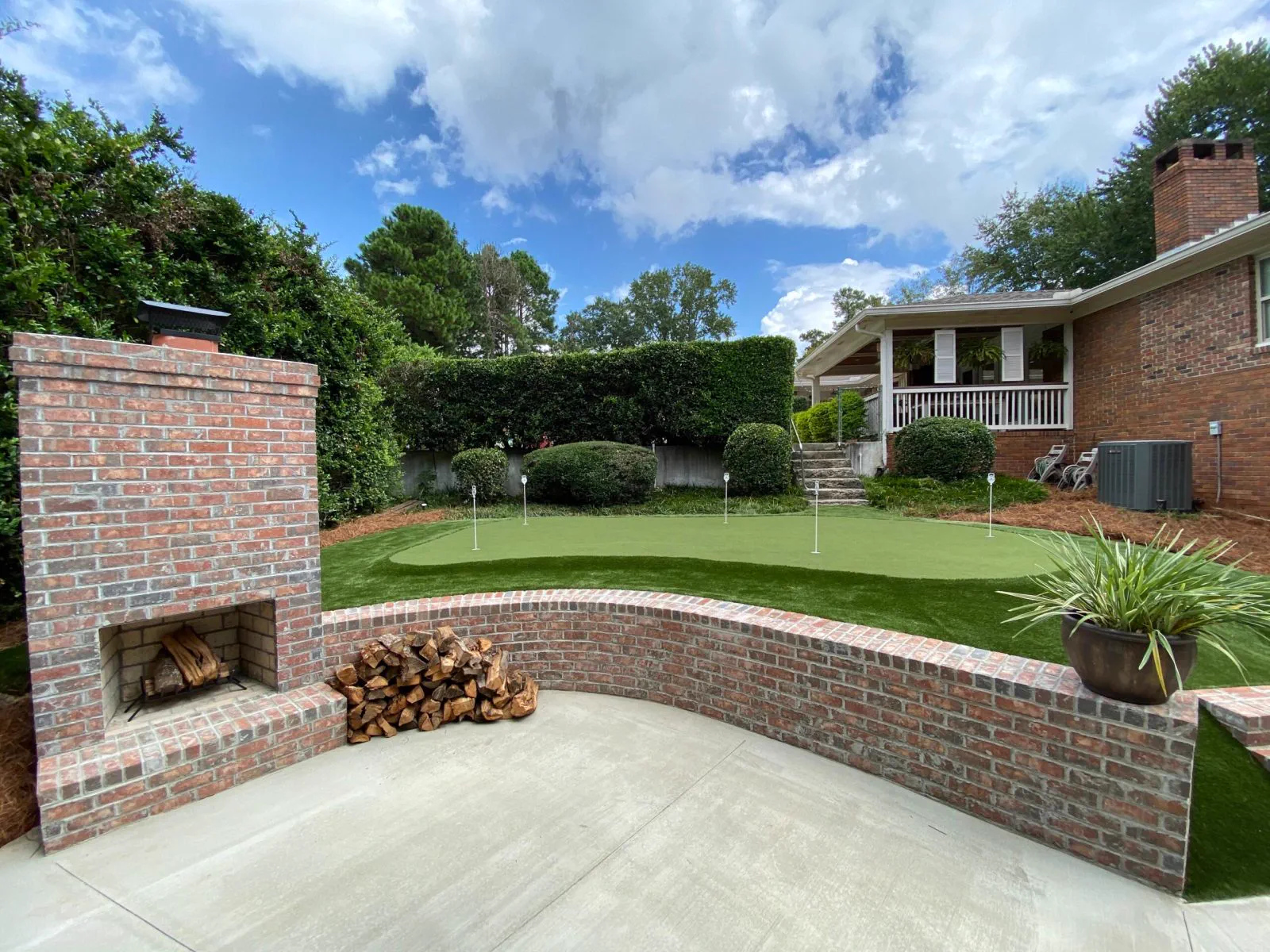 Brick outdoor fireplace and curved seat wall on a concrete patio